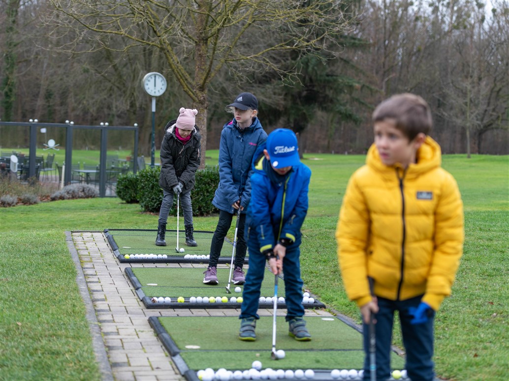 Golftraining auf der Driving Range — Kinder üben den Abschlag